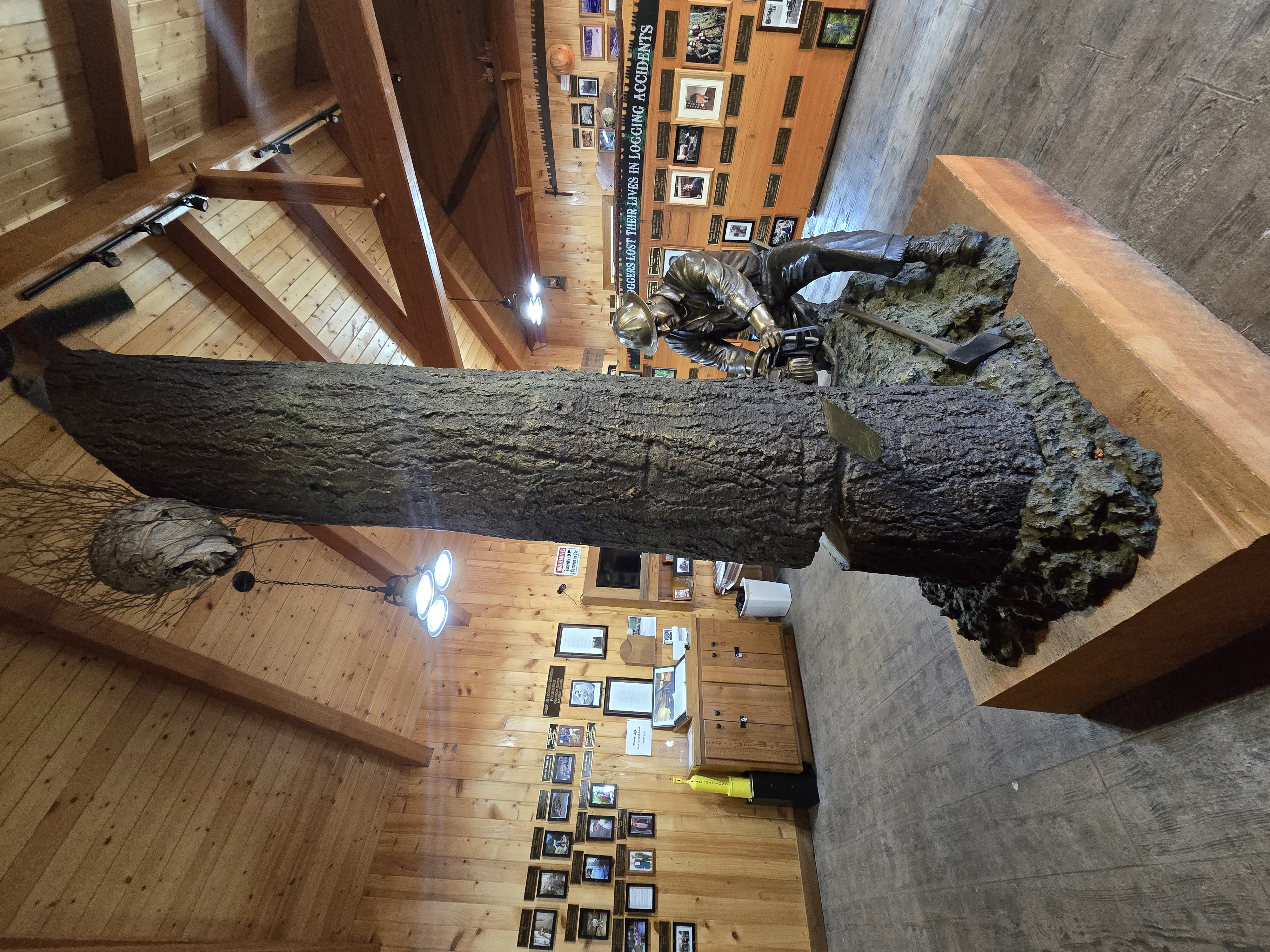 Bronze Man working the chainsaw — full memorial room view