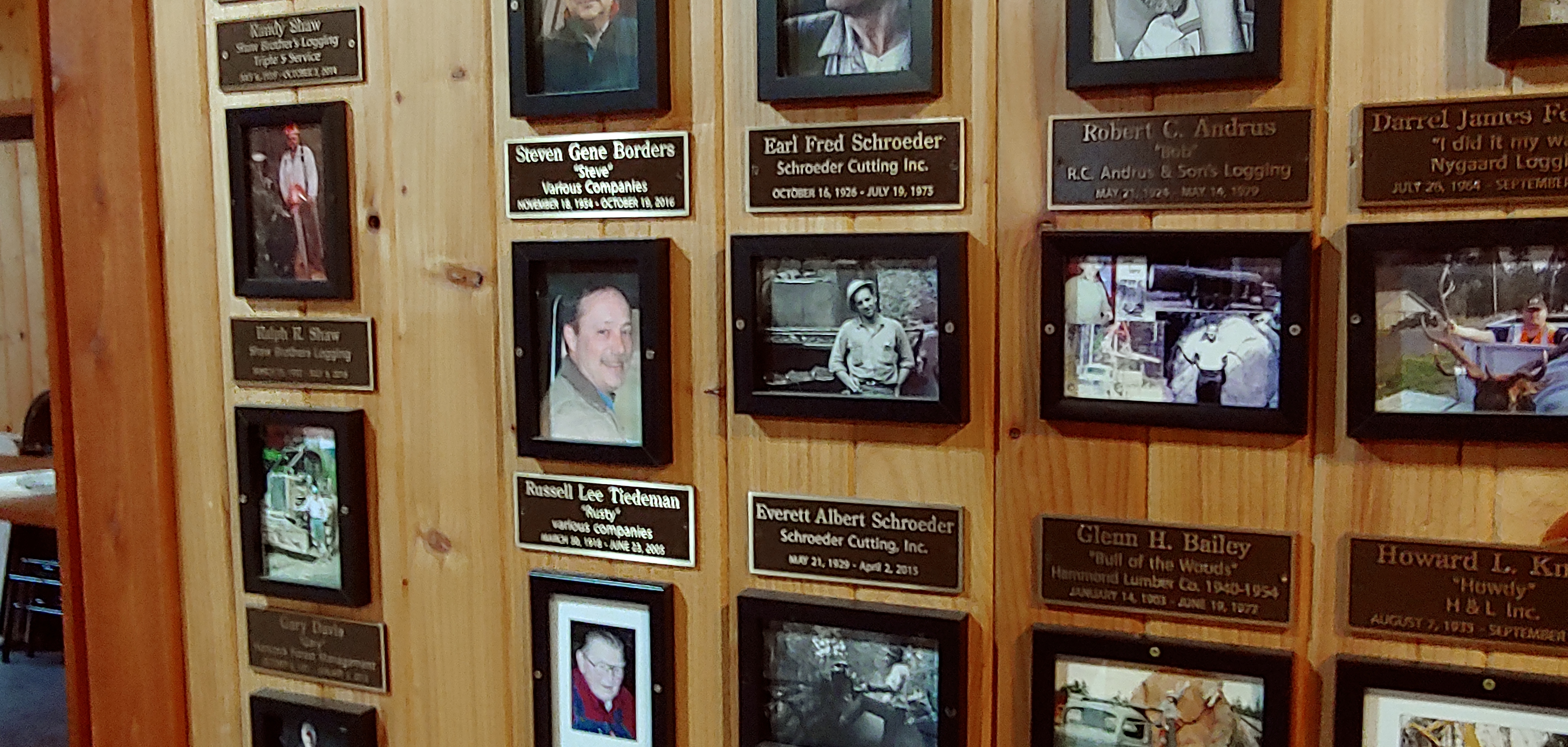 The inner memorial wall at Camp 18 — copper plaques, faces and names of Pacific Northwest loggers